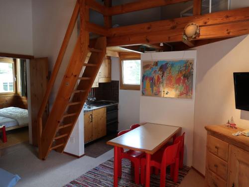 Zimmer mit einem Tisch und einer Küche mit einem Loft. in der Unterkunft Apartment Casa Girun-1 by Interhome in Flims