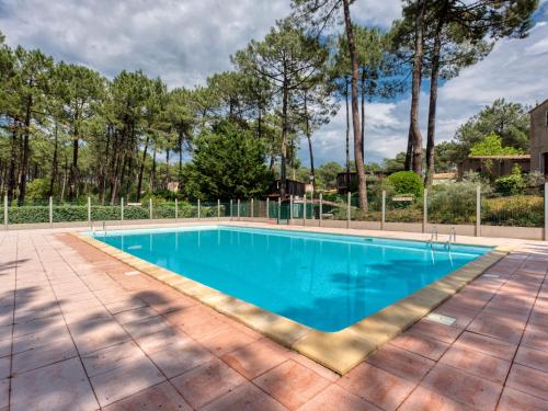 an empty swimming pool in a yard with trees at Holiday Home Les Palombes-8 by Interhome in Lacanau-Océan