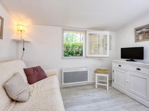 a living room with a couch and a flat screen tv at Holiday Home Les Palombes-8 by Interhome in Lacanau-Océan