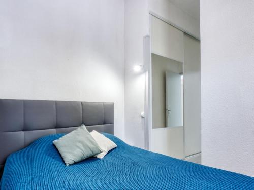 une chambre avec un lit bleu et un miroir dans l'établissement Holiday Home Les Palombes-8 by Interhome, à Lacanau-Océan