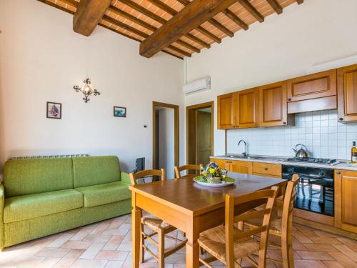 a kitchen with a table and a green couch at Apartment Montereggi-2 by Interhome in Limite