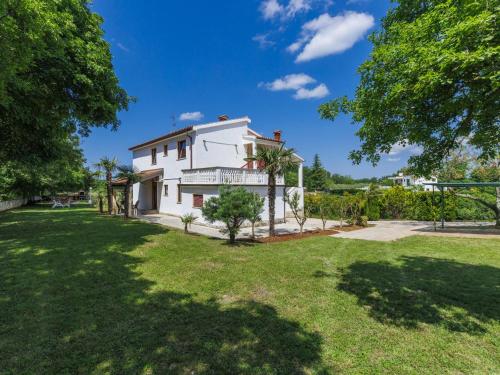 biały dom z trawnikiem i drzewami w obiekcie Apartment Ana-2 by Interhome w mieście Jehnići