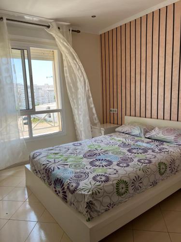 1 dormitorio con 1 cama grande y ventana en 1 COMP MARJANE en Tánger