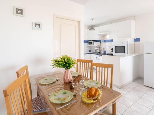 a kitchen with a wooden table with food on it at Apartment Patguyflor-2 by Interhome in Mimizan-Plage