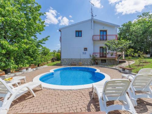 una foto di una villa con piscina e sedie di Apartment Ana-3 by Interhome a Jehnići
