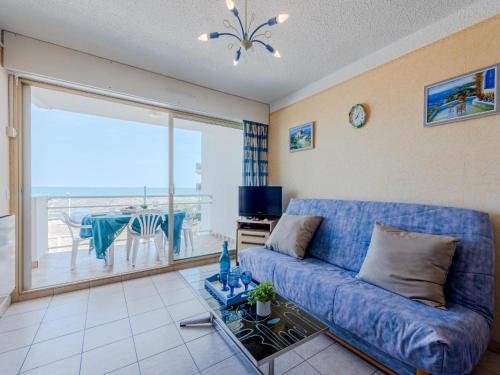 - un salon avec un canapé bleu et une vue sur l'océan dans l'établissement Apartment Amphitrite-1 by Interhome, au Barcarès