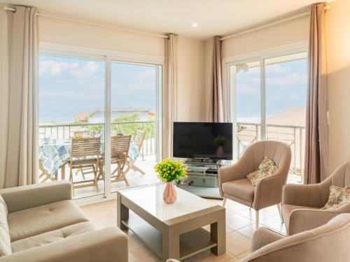 a living room with a television and a balcony at Apartment Côte Sud-4 by Interhome in Mimizan-Plage