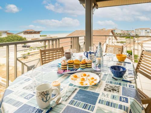 une table avec de la nourriture pour le petit-déjeuner au sommet d'un balcon dans l'établissement Apartment Côte Sud-4 by Interhome, à Mimizan-Plage