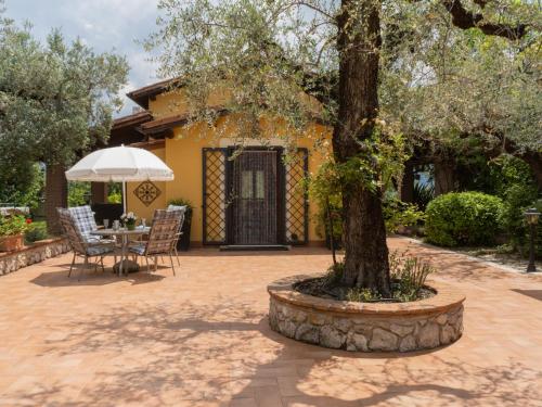a patio with a tree and a table and chairs at Holiday Home Olive Grove Sabina by Interhome in Canneto