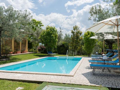 - Piscina con mesa, sillas y sombrilla en Holiday Home Olive Grove Sabina by Interhome, en Canneto