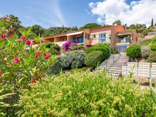 une maison avec un jardin orné de fleurs roses dans l'établissement Apartment Les Hauts des Issambres-1 by Interhome, à La Garonnette-Plage