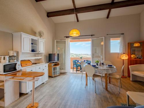 une cuisine et un salon avec une table et des chaises dans l'établissement Apartment Les Hauts des Issambres-1 by Interhome, à La Garonnette-Plage