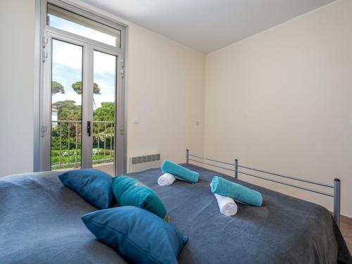 une chambre avec un lit avec des oreillers bleus et une fenêtre dans l'établissement Apartment La Bouée-1 by Interhome, à Antibes