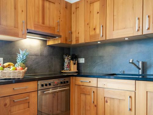 - une cuisine avec des placards en bois et un évier dans l'établissement Apartment Les Cimes Blanches B 401 by Interhome, à Nendaz
