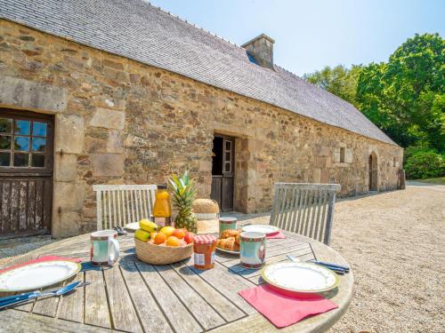 a wooden table with food on it in front of a building at Holiday Home Manoir Kerprigent by Interhome in Cité