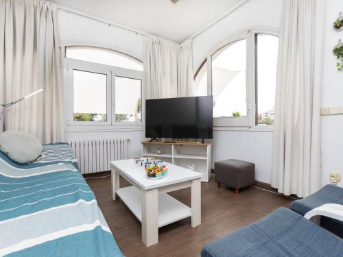 - un salon avec une télévision, un canapé et une table dans l'établissement Holiday Home Platja by Interhome, à Lloret de Mar