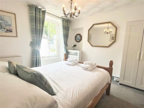a bedroom with a large bed and a mirror at Holiday Home Violet by Interhome in Looe