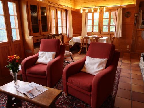 een woonkamer met 2 stoelen en een tafel bij Chalet Les Clarines by Interhome in Grimentz