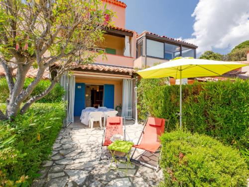 un patio avec une table, des chaises et un parasol dans l'établissement Apartment Les Hauts des Issambres-11 by Interhome, aux Issambres