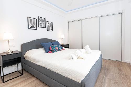 ein Schlafzimmer mit einem großen Bett mit einem Nachttisch und einem Bett der Marke sidx sidx sidx. in der Unterkunft Acogedor apartamento en Estepona centro by Rent Me in Estepona