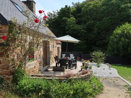 a patio with a table and chairs and an umbrella at Holiday Home Entre Terre et Mer - PML102 by Interhome in Ploumilliau