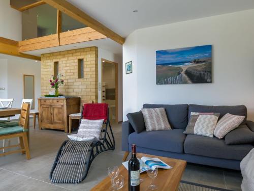 a living room with a couch and a table at Chalet Ty Coat by Interhome in La Forêt-Fouesnant