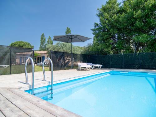 uma piscina com um guarda-sol e uma mesa e banco em Holiday Home Les Oliviers - SAE110 by Interhome em Salernes