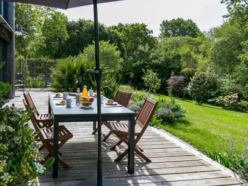 - une table avec des chaises et un parasol sur la terrasse dans l'établissement Chalet Ty Coat - LFF107 by Interhome, à La Forêt-Fouesnant