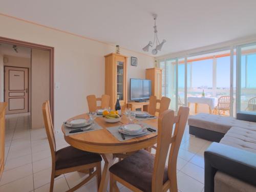 a dining room with a table with chairs and a television at Apartment L'Escale Vendée Globe - LSD300 by Interhome in Les Sables-dʼOlonne