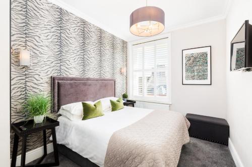 a bedroom with a large white bed and a window at L-Spa Boutique Apartments in Leamington Spa