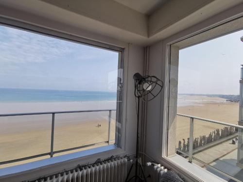 Cette chambre dispose de deux fenêtres offrant une vue sur la plage. dans l'établissement Apartment Le Grand Large by Interhome, à Saint-Malo