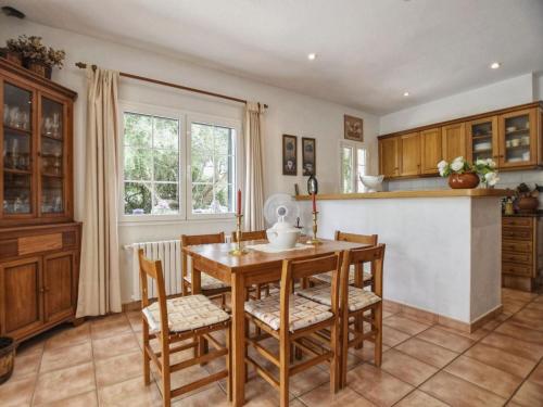 a kitchen with a wooden table and chairs at Villa Tórtolas by Interhome in Alaior