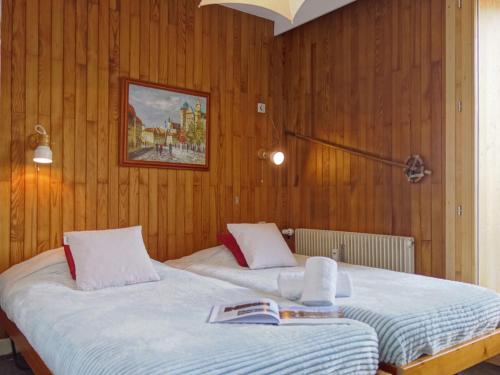 two beds in a room with wooden walls at Apartment Les Grandes Balmes I et II - Le Lac-9 by Interhome in Tignes