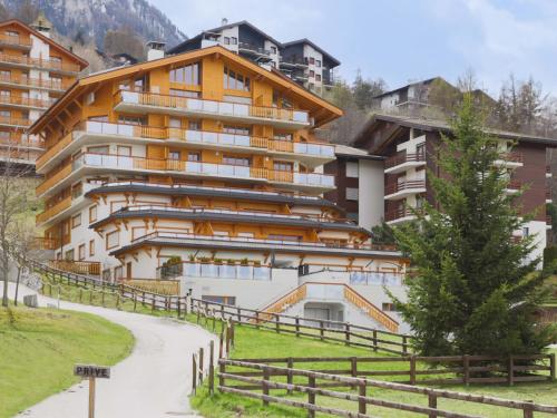een groot appartementencomplex in de bergen met een pad bij Apartment Cor des Alpes 16 by Interhome in Nendaz