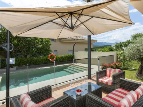 eine Terrasse mit einem Tisch und einem großen Sonnenschirm in der Unterkunft Holiday Home Volca by Interhome in Olot