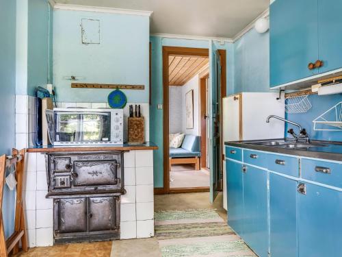 - une cuisine avec des placards bleus et une cuisinière ancienne dans l'établissement Holiday Home Ebbabolet by Interhome, à Tibro