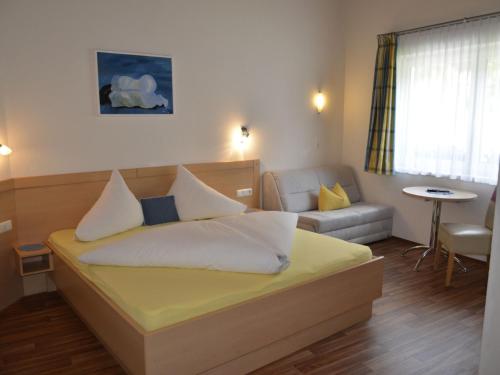 1 dormitorio con cama, sofá y mesa en Apartment Apart Garni Wachter by Interhome, en Kappl