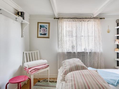 1 dormitorio con 1 cama, 1 silla y 1 ventana en Holiday Home Bergkvara - SND033 by Interhome, en Bergkvara
