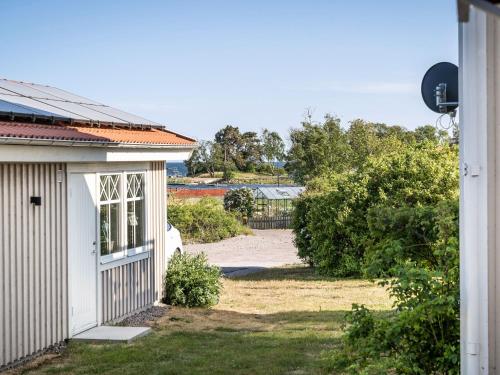 a house with a door and a yard with bushes at Holiday Home Bergkvara by Interhome in Bergkvara