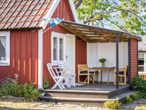 a red and white shed with a table on a deck at Holiday Home Bergkvara by Interhome in Bergkvara