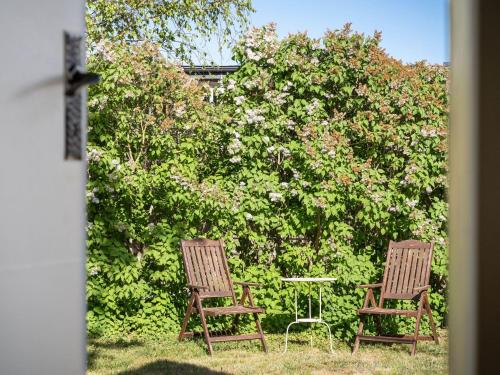 dos sillas y una mesa frente a un arbusto en Holiday Home Bergkvara - SND033 by Interhome, en Bergkvara