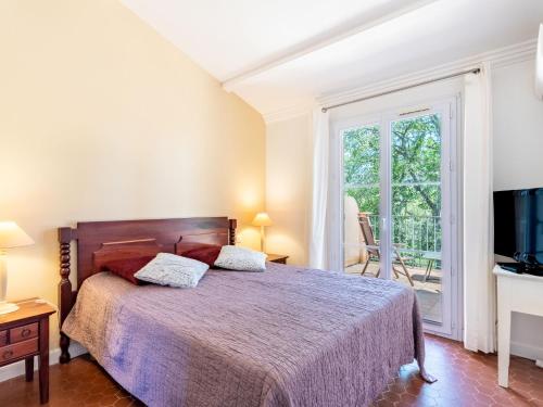 グリモーにあるHoliday Home Les Restanques Golfe Saint Tropez-6 by Interhomeのベッドルーム(ベッド1台、テレビ、バルコニー付)