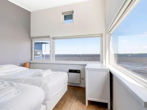 a bedroom with two beds and a large window at Holiday Home Rietwoning 16 by Interhome in Anjum