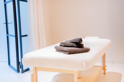 - une pile de serviettes assises au-dessus d'une table de salle de bains dans l'établissement Mas La Bergerie, à Eygalières