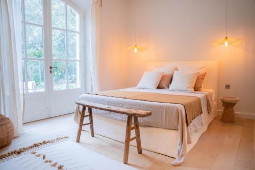 - une chambre avec un grand lit et un banc à côté d'une fenêtre dans l'établissement Mas La Bergerie, à Eygalières