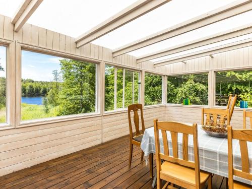 - une salle à manger avec une table, des chaises et des fenêtres dans l'établissement Holiday Home Erikstorp Tvåan - B, à Olofström