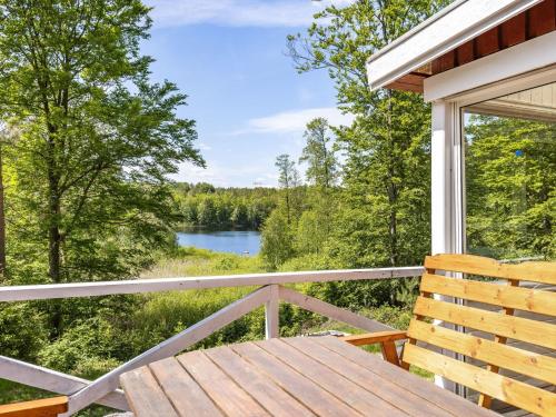 - une terrasse couverte avec un banc en bois et une vue sur le lac dans l'établissement Holiday Home Erikstorp Tvåan - B, à Olofström