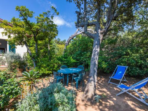 a patio with a table and chairs under a tree at Holiday Home I Lecci by Interhome in Castiglioncello