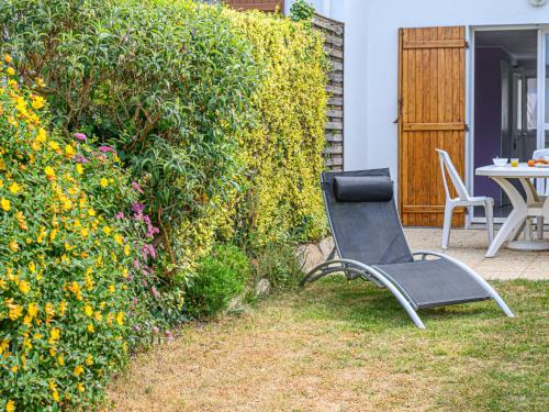 a chair sitting in the yard next to a hedge at Holiday Home Maison de la Plage by Interhome in Carnac-Plage