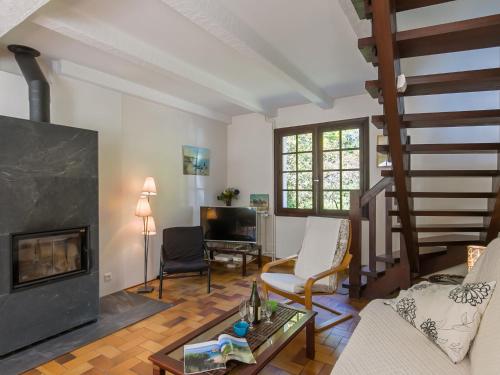 uma sala de estar com lareira e uma escada em Holiday Home Bellevue - MSR103 by Interhome em Moëlan-sur-Mer